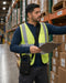 Newland shoulder sling holster worn crossbody by a warehouse worker reviewing a clipboard beside pallet rack inventory.