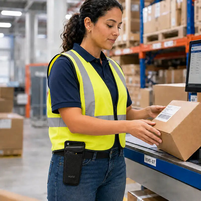 Worker wearing a Newland mobile terminal mountable case while handling a package at a warehouse workstation for shared device access.