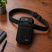 Castles handheld POS terminal in black Agoz holster with waist belt on tabletop