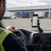 Newland mobile computer mounted on a dashboard cradle inside a delivery vehicle at an outdoor loading dock.