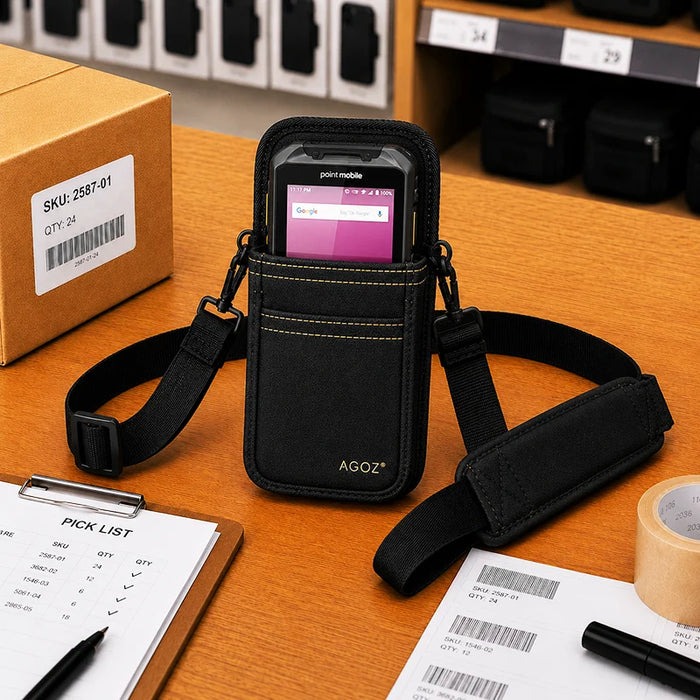 Black AgozTech Point Mobile crossbody holster with Point Mobile handheld device displayed on a warehouse packing desk, surrounded by a pick list clipboard, barcode labels, packing tape, and shipping box.