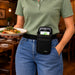 Restaurant server carrying a plated meal while wearing a black Agoz Orderman POS holster with adjustable waist belt for convenient device access.