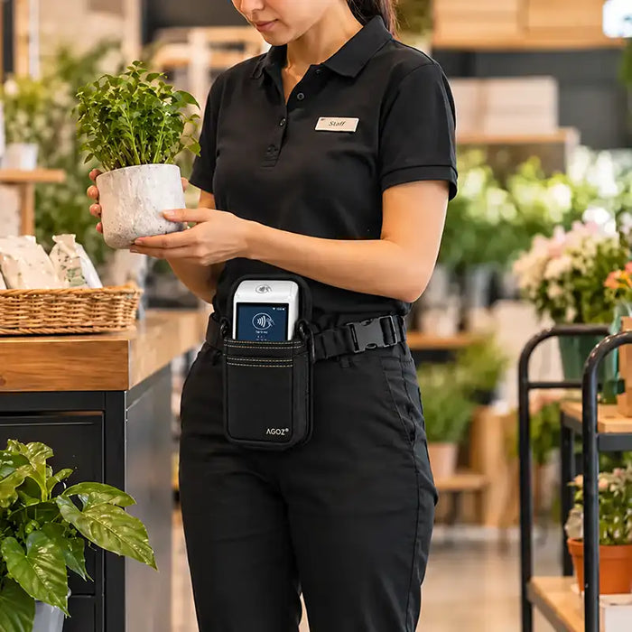 Retail employee wearing Agoz Saturn 1000F2 POS holster on an adjustable waist belt while arranging plants in a flower shop.