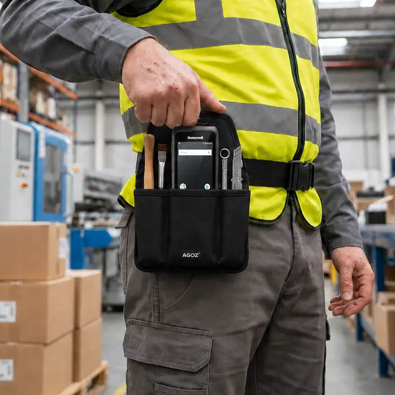 Close-up of an AgozTech black tool pouch holding a Honeywell mobile computer and tools on a warehouse worker’s waist belt.