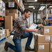 Warehouse worker using a mobile scanner while wearing an AgozTech waist belt holster with mobile printer for route staging.