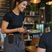 Waitress wearing an AgozTech Sunmi POS handheld terminal holster clipped to her apron while serving food in a restaurant.
