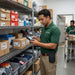Worker using Point Mobile barcode scanner with AgozTech holster in stockroom setting