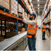 Warehouse worker scanning inventory with a trigger-handle scanner while wearing an AgozTech Chainway scanner holster on a waist belt for hands-free warehouse operations.