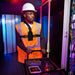 Field technician wearing Unication radio chest harness holster for hands-free access